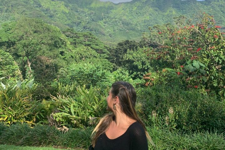 a woman standing in front of a mountain