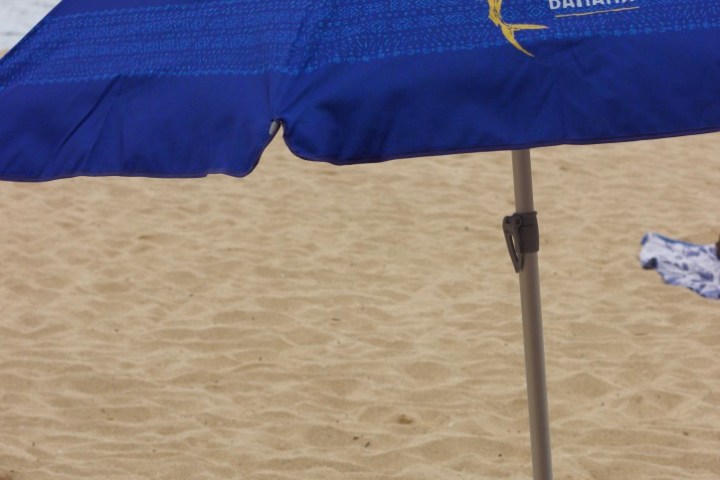 an umbrella sitting on top of a sandy beach